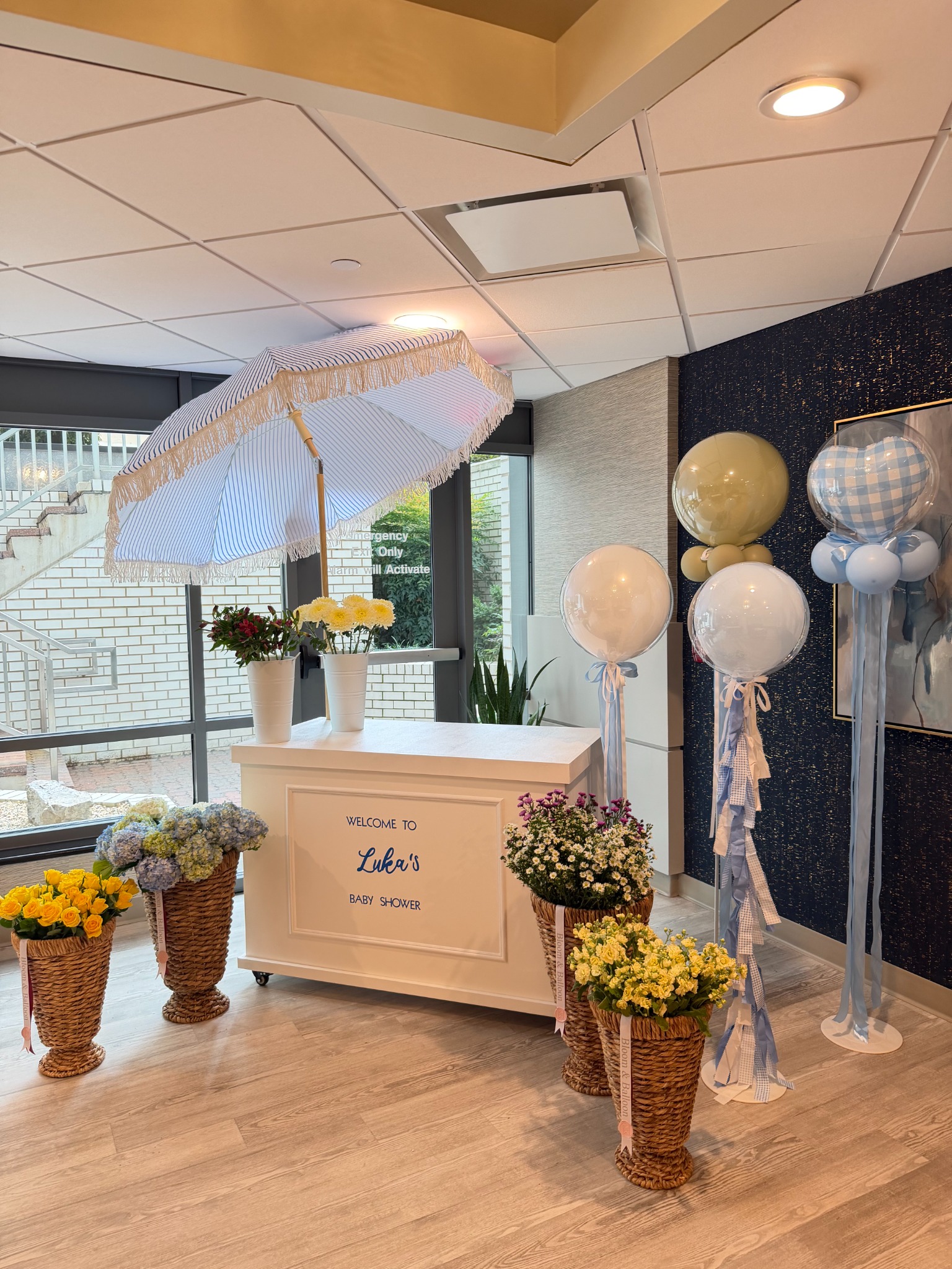 Bloom Bar with flowers and blue balloons at Luka’s baby shower